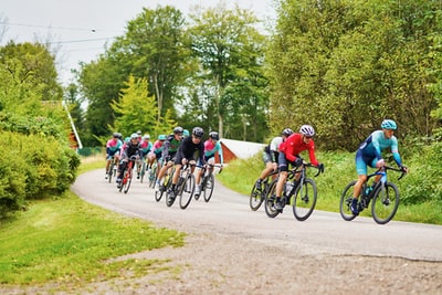 People on the road during the day to ride a bicycle
